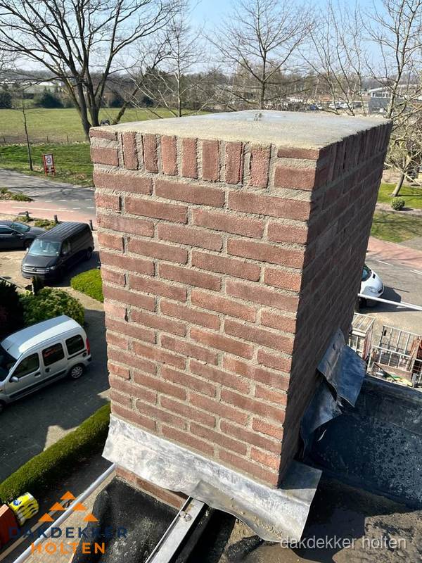 Gemetselde schoorsteen met loodaansluiting op dak in Holten Gemetselde schoorsteen met loodaansluiting op dak in Holten